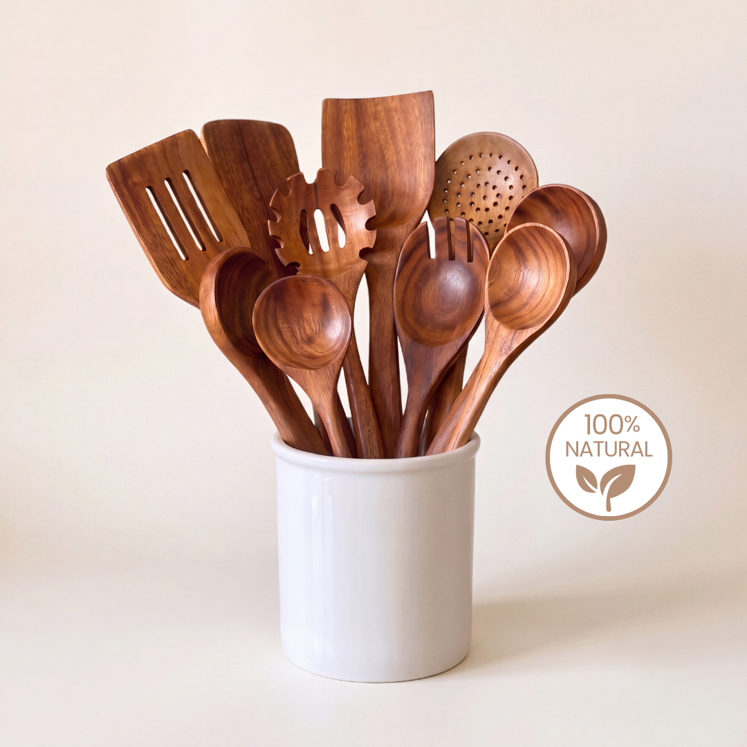A set of natural wood kitchen utensils, including spoons, spatulas, and a slotted spoon, gathered in a white ceramic container against a warm beige background. A circular badge on the right reads '100% NATURAL'.